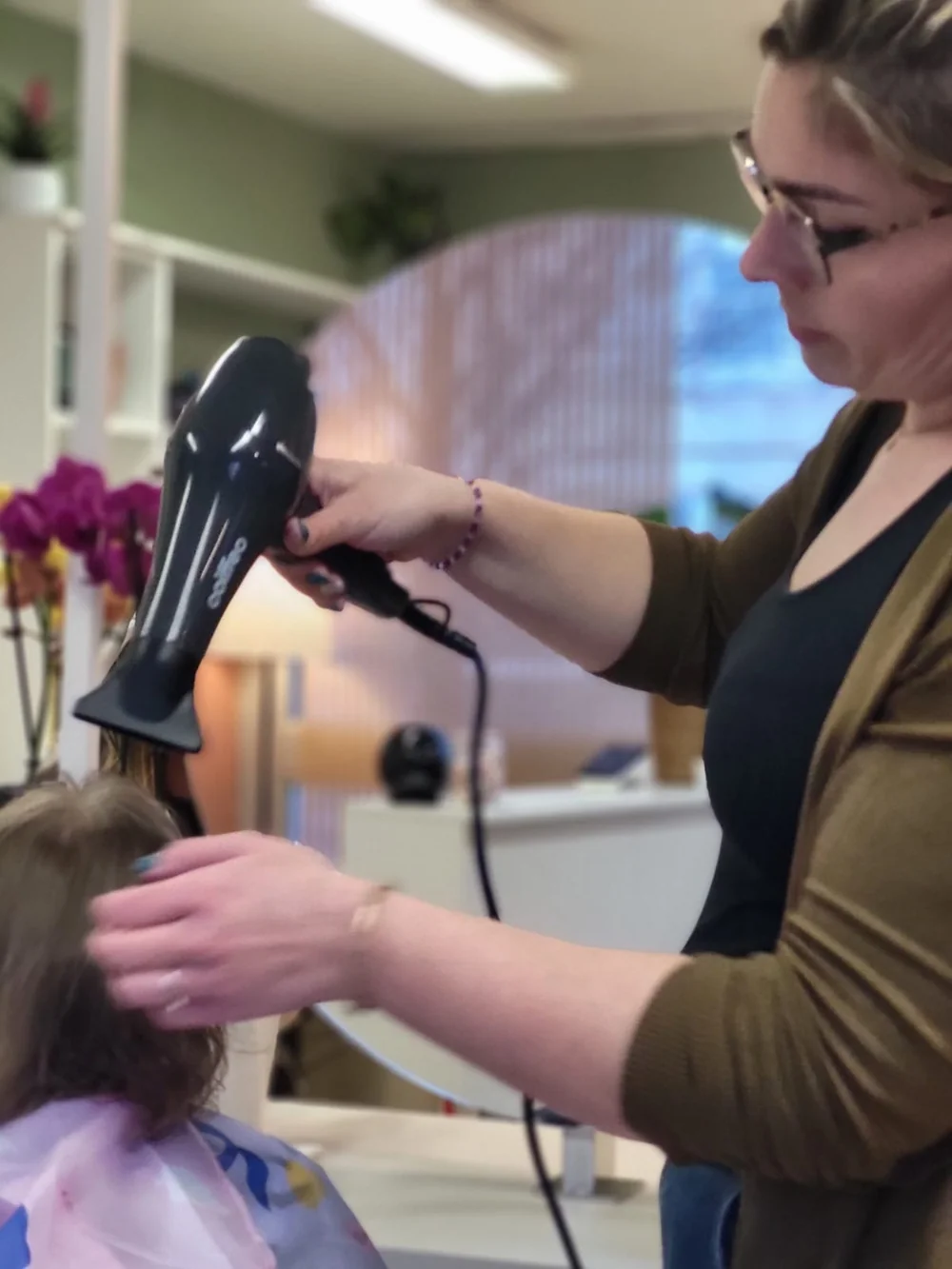 Audrey réalisant un brushing sur une jeune cliente